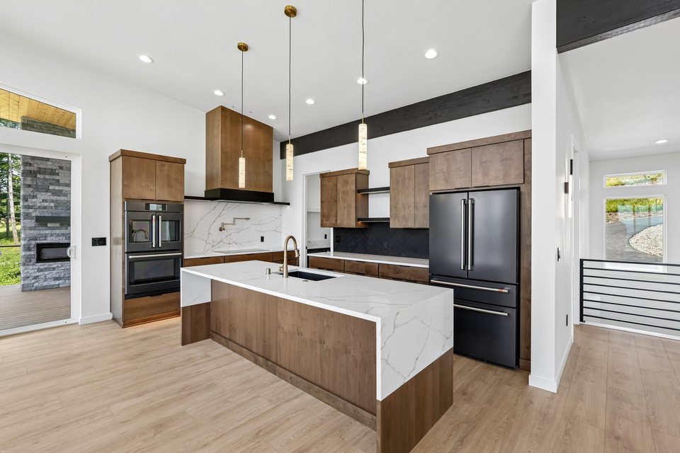 Contemporary kitchen with wood cabinetry and waterfall island